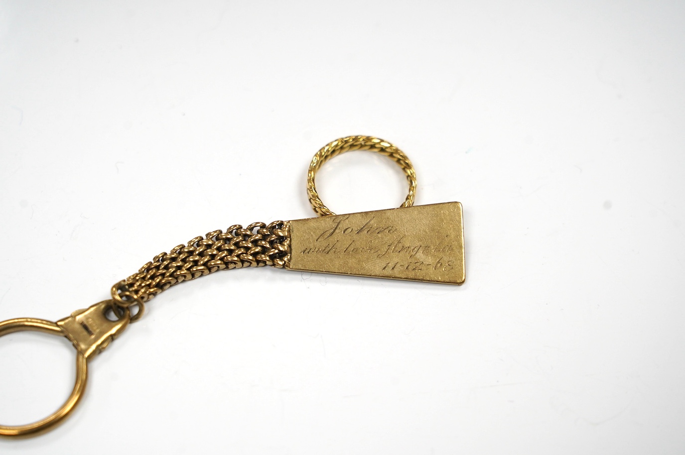 A 9ct gold key chain, with engraved inscription and a yellow metal band, gross weight 17.2 grams. Condition - fair